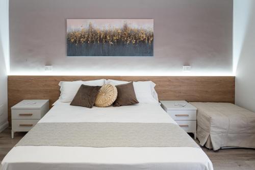 een slaapkamer met een wit bed en 2 nachtkastjes bij A Due Passi - Guest House in Santo Stefano di Camastra