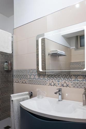 a bathroom with a sink and a mirror at A Due Passi - Guest House in Santo Stefano di Camastra