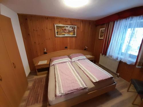 a bedroom with a bed with towels on it at Ciasa Rosada in San Vigilio Di Marebbe