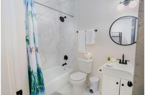 a white bathroom with a tub and a toilet and a sink at Magnificent 4BR Near Famous Riverwalk and Downtown in San Antonio