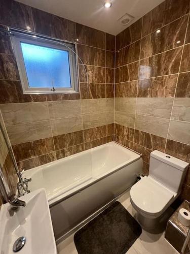 a bathroom with a tub and a toilet and a sink at Chester road,N17,Bright Studio in London