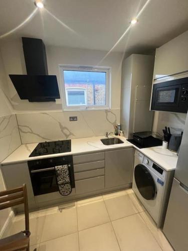 a small kitchen with a sink and a stove at Chester road,N17,Bright Studio in London