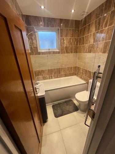 a bathroom with a tub and a toilet and a sink at Chester road,N17,Bright Studio in London