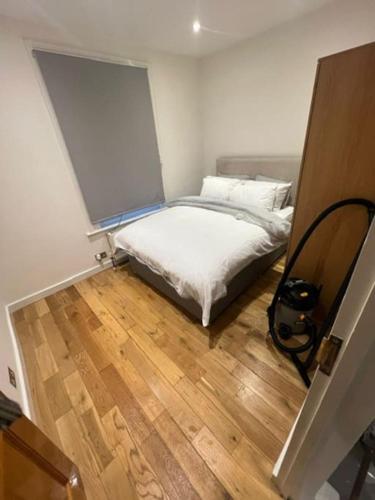 a small bedroom with a bed and a wooden floor at Chester road,N17,Bright Studio in London