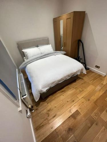 een bed in een kamer met een houten vloer bij Chester road,N17,Bright Studio in Londen