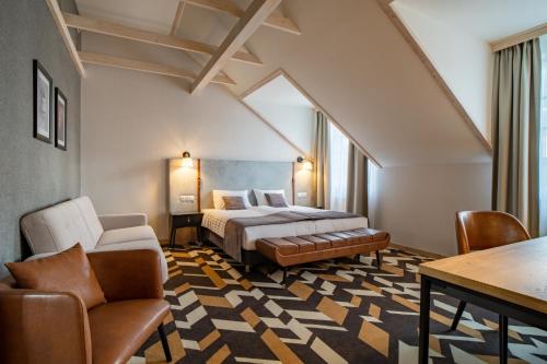 a bedroom with a bed and a table and chairs at Santa Natura Resort & SPA in Nowa Wieś