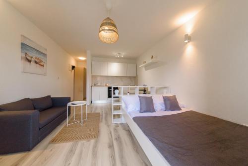 1 dormitorio con 1 cama grande y 1 sofá en Donata Apartments Zadar, en Zadar