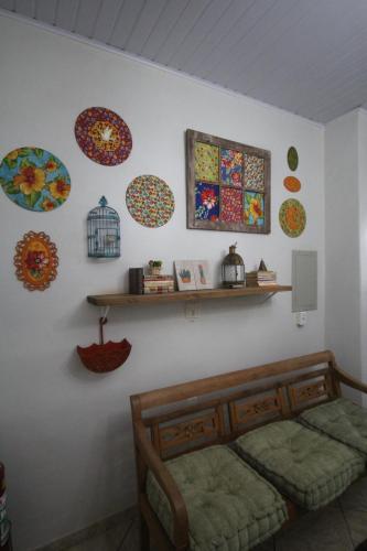 a bedroom with colorful plates on the wall at Pousada Tia Nena in Olímpia