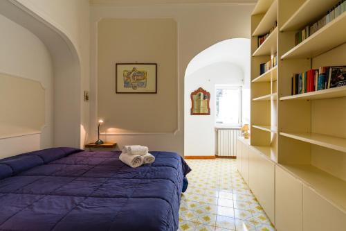 sypialnia z fioletowym łóżkiem i półką na książki w obiekcie Villa Paola - Hidden Panoramic Garden and Terraces by Napoliapartments w mieście Napoli