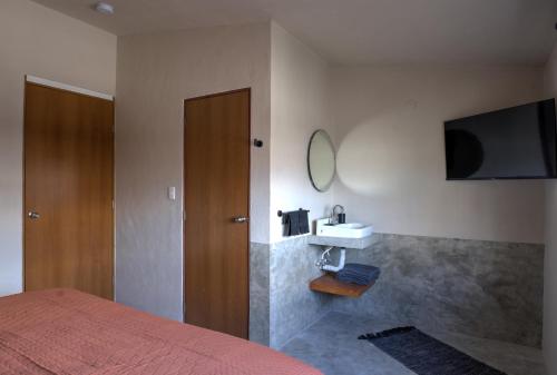 1 dormitorio con 1 cama y TV en la pared en 5BR Beautiful home in downtown Cancun, 10min beach, en Cancún