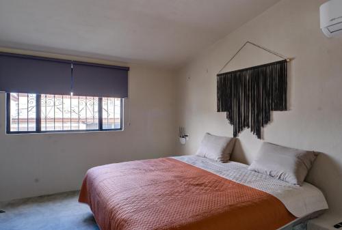 a bedroom with a large bed and a window at 5BR Beautiful home in downtown Cancun, 10min beach in Cancún