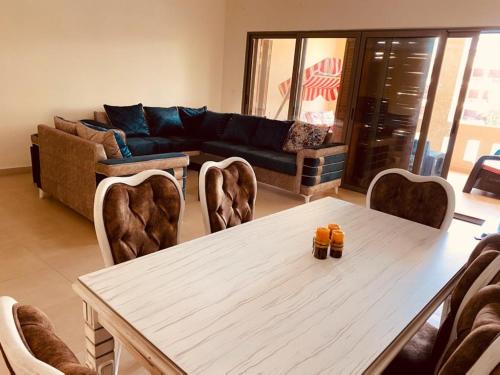 un soggiorno con tavolo, sedie e divano di Tala bay apartments 2 bedroom ad Aqaba