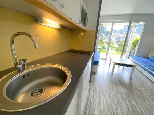 d'un évier dans une cuisine avec une grande fenêtre. dans l'établissement Appartement à Fouesnant avec piscine chauffée, proche plage et GR34 - FR-1-481-109, à Fouesnant