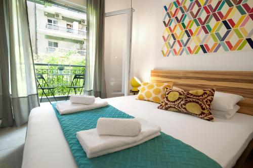 a bedroom with a large bed with towels on it at Mazi Rooms Venizelou in Thessaloniki