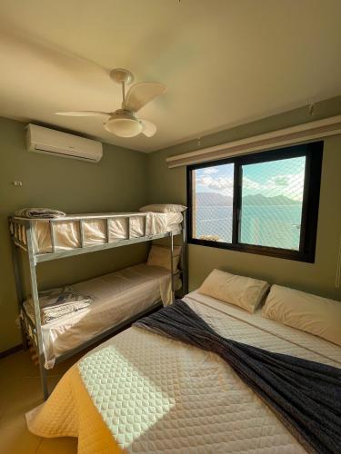 two beds in a room with a window at Apartamento Porto Real Resort (11.1 402) com vista panorâmica in Angra dos Reis