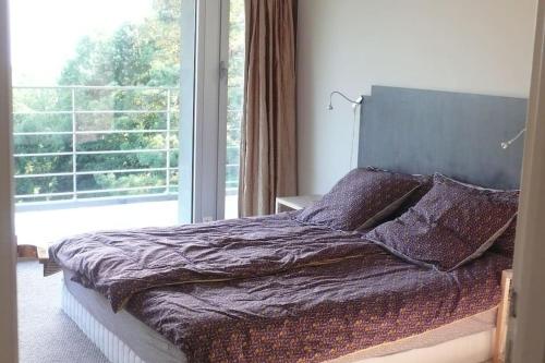 un lit dans une chambre avec une grande fenêtre dans l'établissement Maison d'architecte au lac Léman, à Thonon-les-Bains