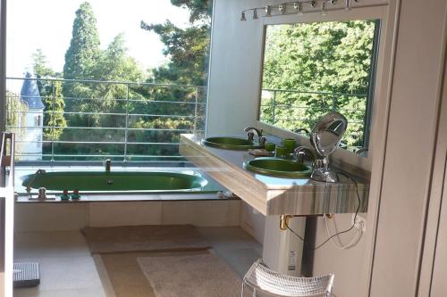 La salle de bains est pourvue d'une baignoire, de 2 lavabos et d'une fenêtre. dans l'établissement Maison d'architecte au lac Léman, à Thonon-les-Bains