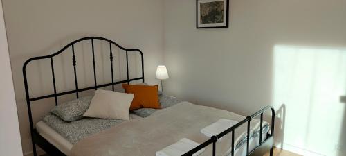 a bedroom with a black bed with pillows on it at Młynarska - słoneczne apartamenty in Piaseczno