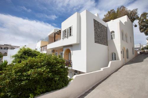 a white house with a staircase in front of it at DELFINI I in Fira