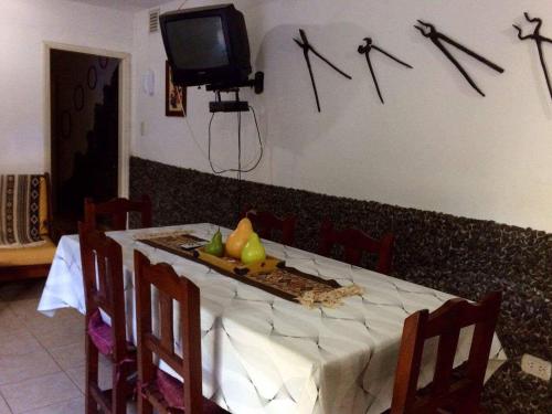 mesa de comedor con TV en la pared en Departamento Pama en Santa Rosa de Calamuchita