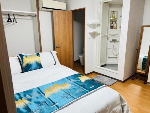 a bedroom with a bed with a blue and yellow blanket at Fukuinn - Vacation STAY 35782v in Takamatsu