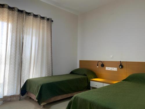 um quarto com 2 camas e uma janela em Le Lézard Vert, Maison d'Affair à Niamey em Niamey