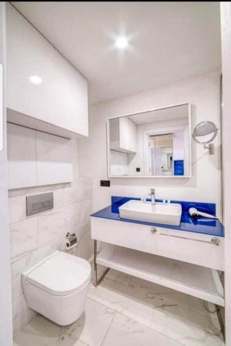 een witte badkamer met een toilet en een wastafel bij Orbi City Batumi in Batoemi