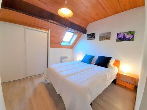 une chambre avec un lit avec un plafond en bois dans l'établissement Saint-Lary Soulan T4 lumineux, 6 couchages, parking, proche pistes, exposé sud - FR-1-457-312, à Vignec