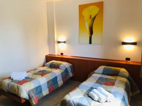 レカナーティにあるHotel Softwoodのベッド2台が備わる客室で、壁には絵画が飾られています。