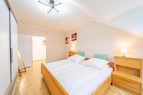 a bedroom with a large white bed in a room at Moderne Dachgeschosswohnung - Parkplatz - Netflix in Coburg