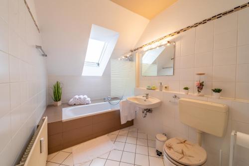 a bathroom with a toilet and a sink and a tub at Moderne Dachgeschosswohnung - Parkplatz - Netflix in Coburg