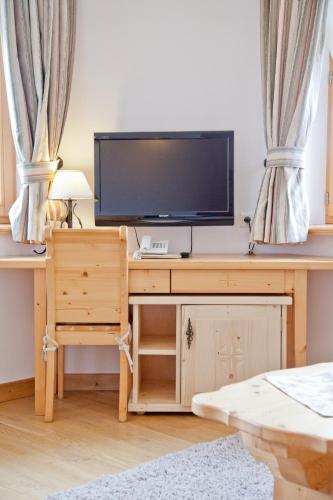 a television on a wooden desk with curtains at Willa Kominiarski Wierch in Zakopane