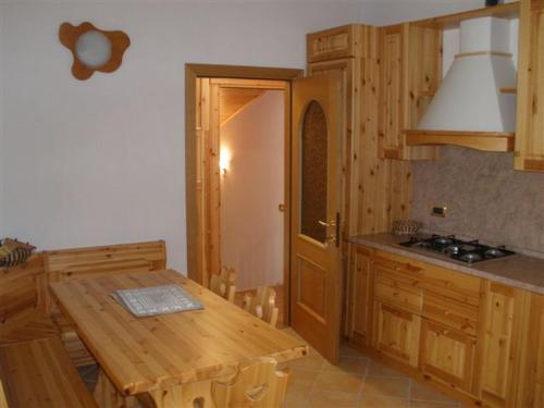 a kitchen with wooden cabinets and a wooden table at APPARTAMENTI in Villa Isabella in Bianzone