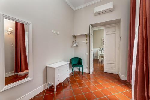 ローマにあるPantheon Luxury Houseのデスクと緑の椅子が備わる客室です。