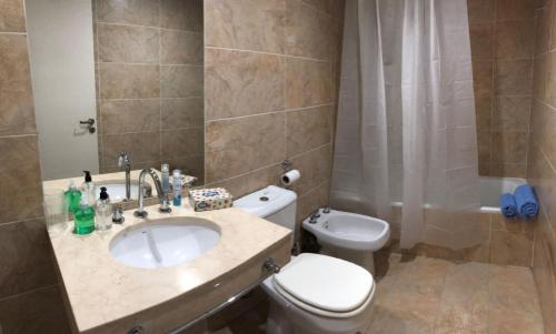 een badkamer met een wastafel, een toilet en een douche bij Estudio minimalista, moderno, confortable, luminoso con piscina in Buenos Aires