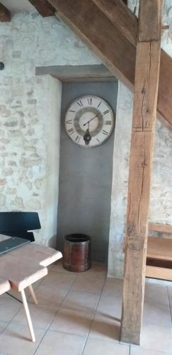 a clock on the side of a wall with a bench at La BerryCurienne proche du Zoo de Beauval Saint-Aignan avec SDB, WC ET SPA PRIVATIF pour chaque chambre in Luçay-le-Mâle