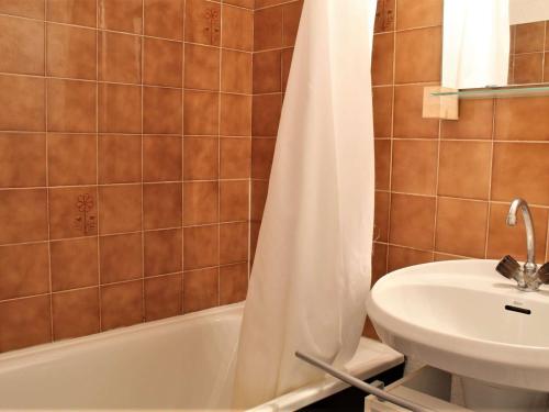 a bathroom with a white shower curtain and a sink at Appartement Risoul, 1 pièce, 4 personnes - FR-1-330-145 in Risoul