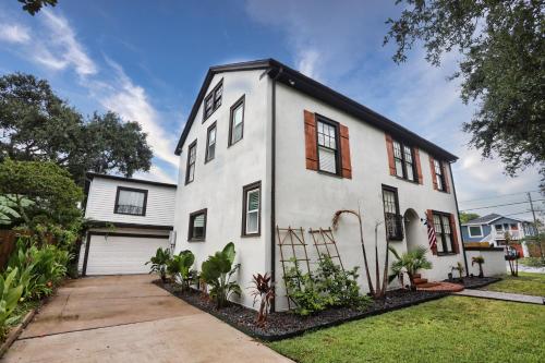 a white house with red windows and a driveway at Historic Home Family Friendly Close to Seawall in Galveston