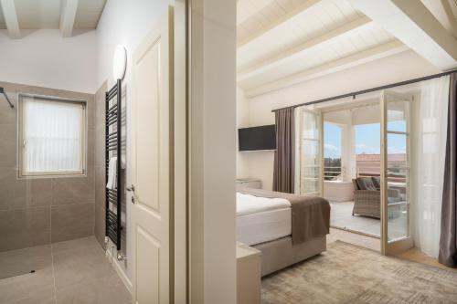a bedroom with a bed and a bathroom with a balcony at Villa Florence by ILC-Istria Luxury Collection in Brtonigla