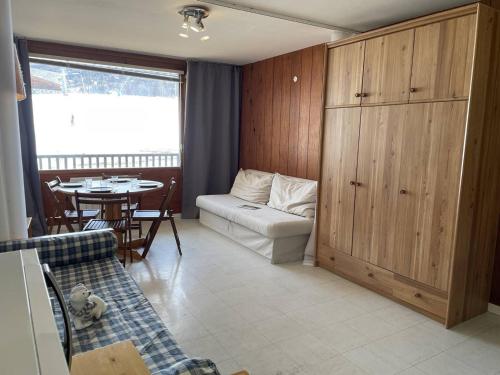 a living room with a couch and a table at Appartement Puy Saint Vincent 1400, 1 pièce, 4 personnes - FR-1-330G-6 in Puy-Saint-Vincent