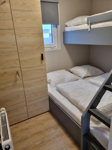 a small room with two bunk beds and a door at Chalet2rent Ameland in Ballum