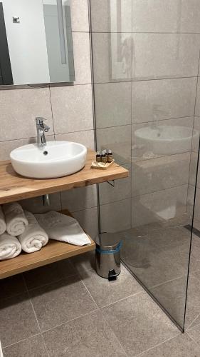 La salle de bains est pourvue d'un lavabo et d'une douche. dans l'établissement Belvedere Restaurant & Rooms, à Topliţa