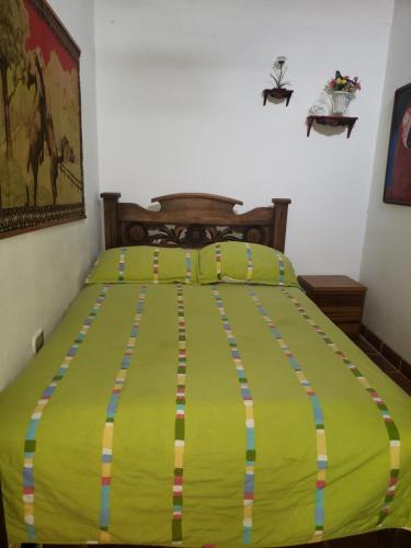 a bed with a yellow comforter in a bedroom at Hotel Campestre Villa Nico in Bochalema
