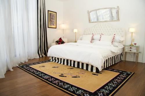 a bedroom with a large white bed with a rug at Tango de Mayo Hotel in Buenos Aires
