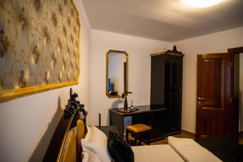 a bedroom with a bed and a dresser and a mirror at Old town villa superior studio in Sibiu