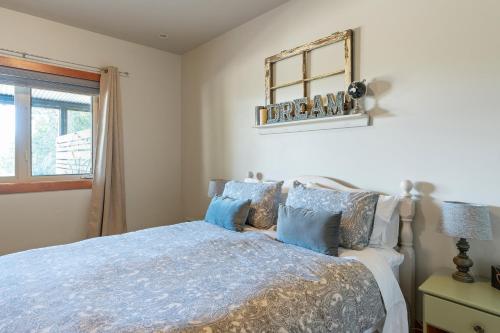 1 dormitorio con cama y espejo en la pared en Shawnigan Hills Guest Suite, en Shawnigan Lake