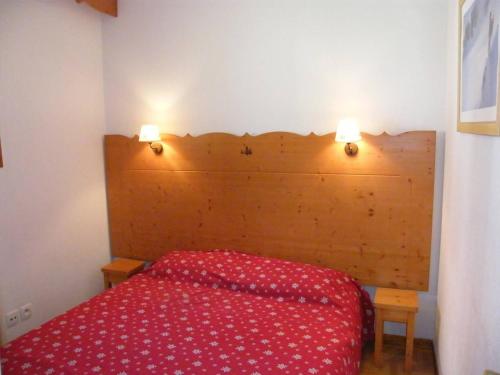 1 dormitorio con 1 cama roja y 2 luces en la pared en Appartement Puy-Saint-Vincent, 2 pièces, 6 personnes - FR-1-330G-80 en Puy-Saint-Vincent
