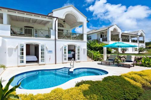a house with a swimming pool in front of it at Royal Westmoreland - Sugar Cane Ridge by Blue Sky Luxury in Saint James