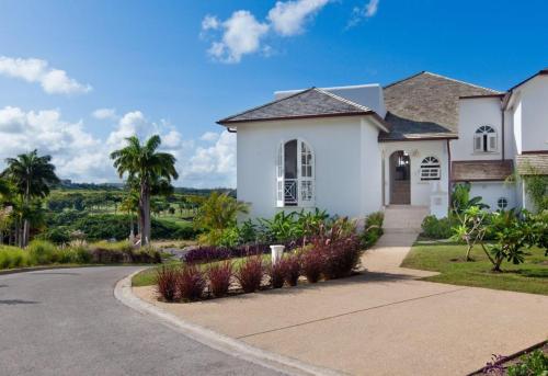 a white house with palm trees and a driveway at Royal Westmoreland - Sugar Cane Ridge by Blue Sky Luxury in Saint James