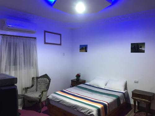 een slaapkamer met een bed en een blauw plafond bij Studio Farida Pyramids View in Caïro